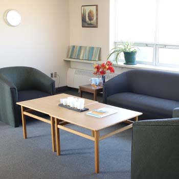 Large common seating area with three couches featuring a center table