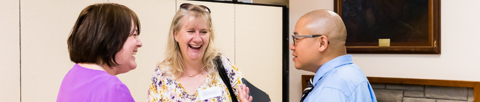 Three People Talking Together at Event