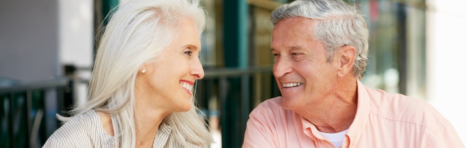 an older couple smiling at each other 