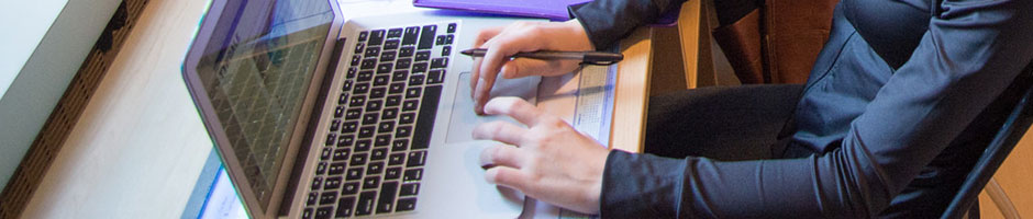 Student at a desk typing on a computer