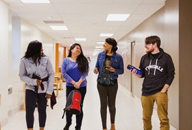 4 students walking in the hallway