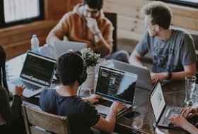 People working on laptops around a table