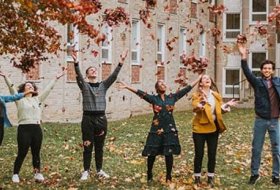 group of students catching falling autumn leaves