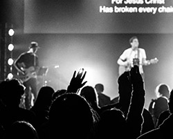 a worship concert in black and white with two men on stage playing guitar and singing to an audience